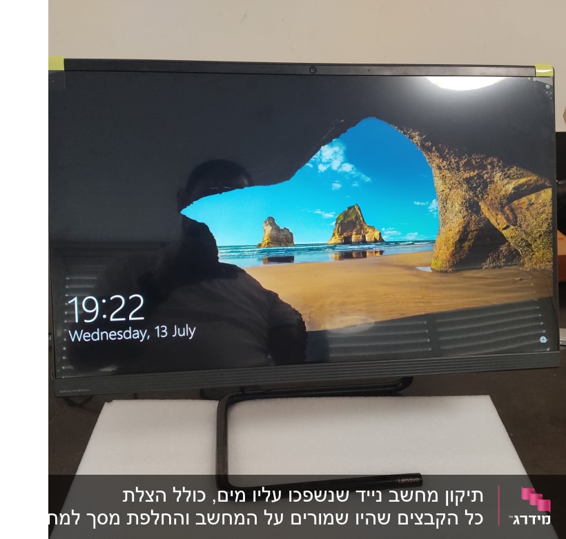 מסך מחשב לנובו עם תמונת רקע של חוף ים